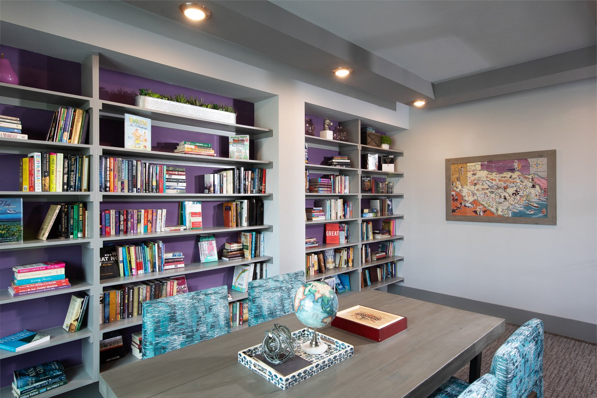 a library with a long table and chairs at a senior apartment community